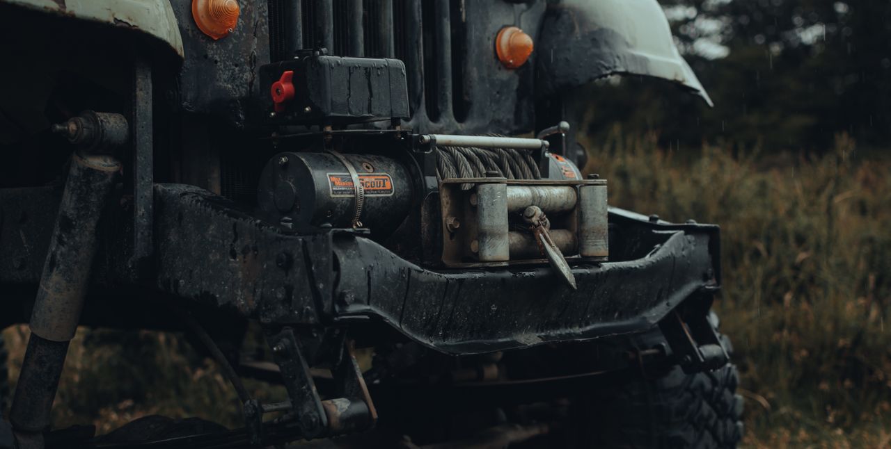 services-03 Detailed view of an off-road vehicle bumper with a metal tow winch, ready for adventure.